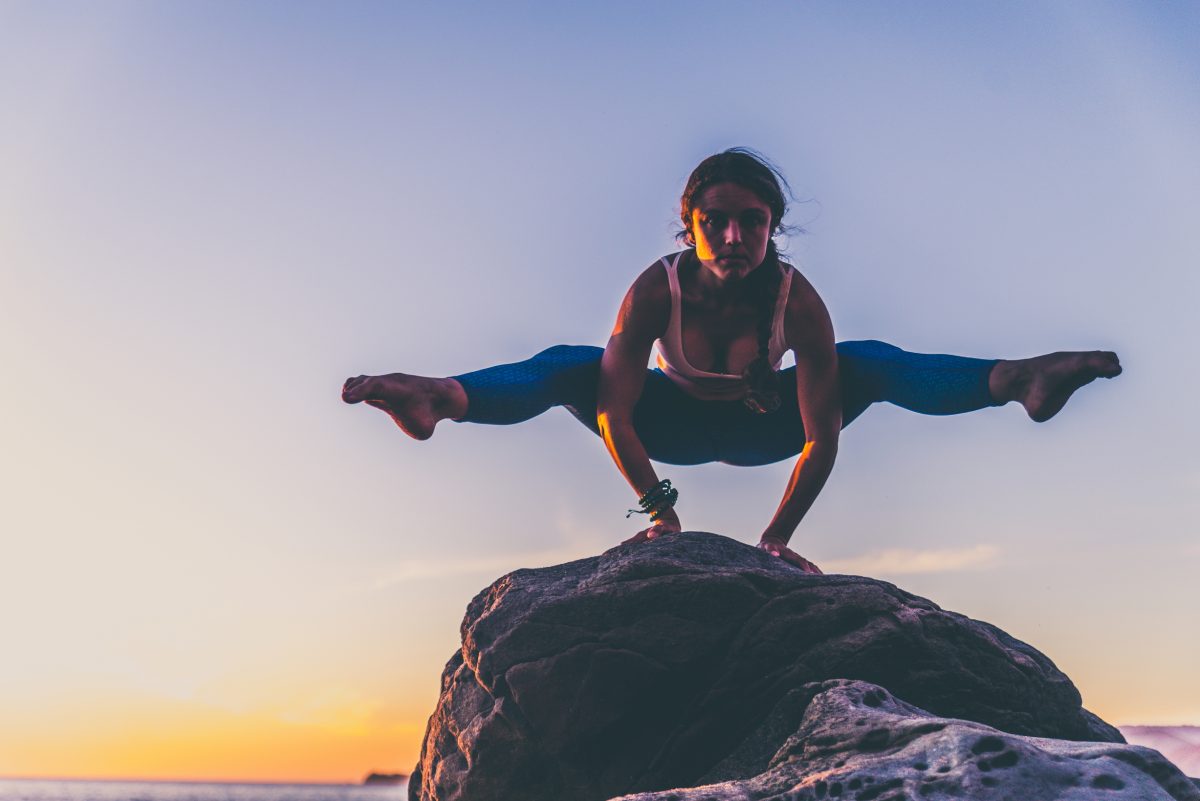 woman yoga balance training on rock on beach - learn kung fu online