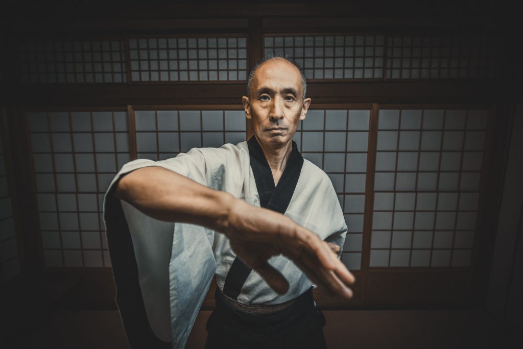 martial arts master doing wing chun bong sao in dojo