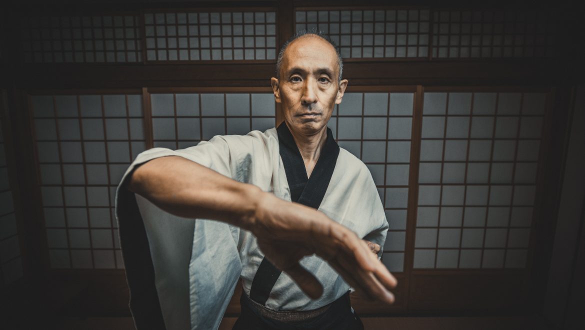 martial arts master doing wing chun bong sao in dojo