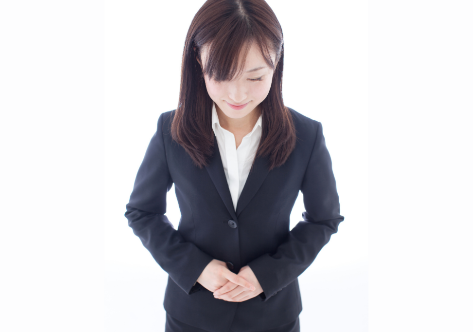Asian woman in suit with hands clasped showing focus and calmness