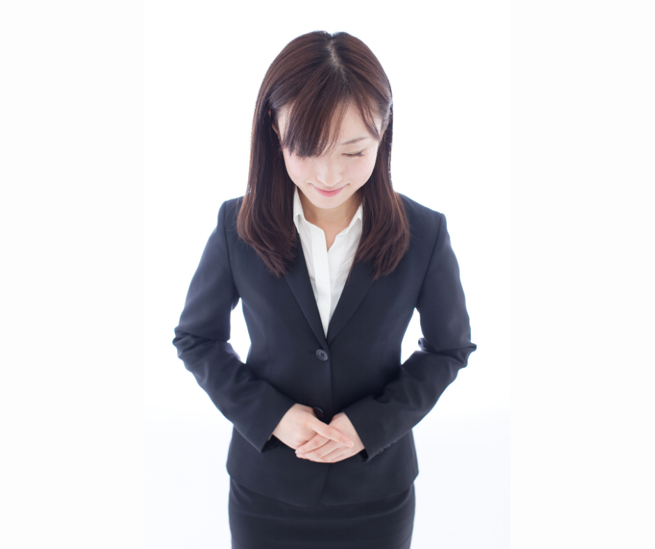 Asian woman in suit with hands clasped showing focus and calmness